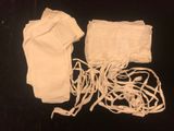 a white cloth bag and a pair of gloves on a black surface