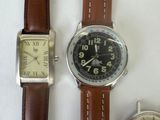 two watches are sitting next to each other on a white surface