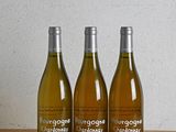 trois bouteilles de vin posées sur une table en bois