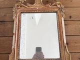 un miroir accroché au mur, avec une personne qui le photographie