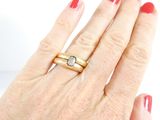a woman ' s hand with a ring and a ring on it