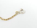 a close up of a gold chain bracelet on a white surface