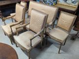 four chairs sitting in a room with a painting on the wall behind them