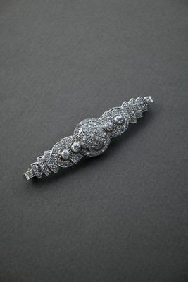 an image of a silver broochle with a bunch of diamonds on it