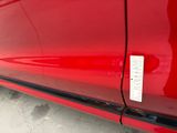 a close up of a red car with a sticker on it