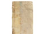 an old book sitting on top of a white surface