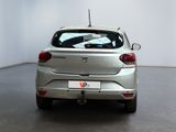 a silver car parked in a room with a white wall