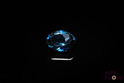 a close up of a blue diamond on a black surface