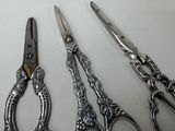 three pairs of scissors sitting next to each other on a table