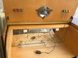 a wooden cabinet with a drawer that has wires and wires in it