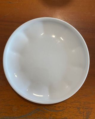 a white plate sitting on a wooden table