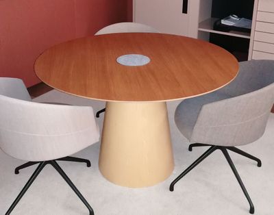 three chairs around a round table in a room