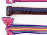 trois ceintures de couleurs différentes ornées d'un nœud rose sur fond blanc