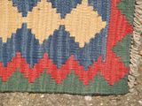 a colorful rug on the ground with a cat laying on it