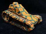 a yellow and green toy tank sitting on a black surface