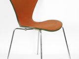 an orange chair with chrome legs and a green seat on a white background