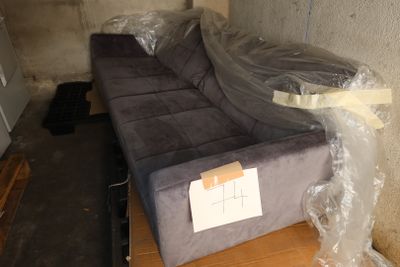 a couch that is wrapped in plastic and sitting on a table