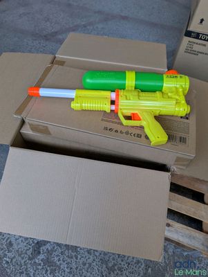 a yellow and green toy gun on top of a cardboard box