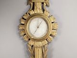 une horloge en or sur le mur avec un oiseau dessus