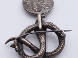a close up of a snake and a coin on a white surface