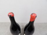 two black bottles with red caps sitting on a table