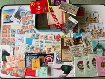 une valise remplie de timbres et d'autres objets, posée par terre