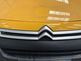 a close up of a yellow citroen car parked in a parking lot