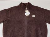 La veste est marron et porte une étiquette blanche.
