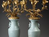 une paire de vases anciens contenant des fleurs, sur fond gris
