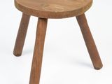 a small wooden stool with three legs on a white background