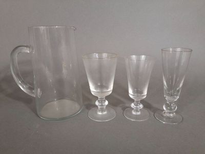 trois verres transparents et un pichet posés les uns à côté des autres sur une table
