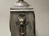 a silver clock with a bird on top of it