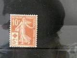 Quatre timbres de tailles et de couleurs différentes sont exposés dans une vitrine.