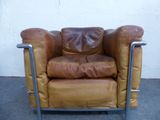 a brown leather chair with a metal frame on the floor