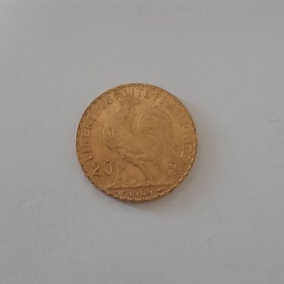 une pièce d'or posée sur une surface blanche