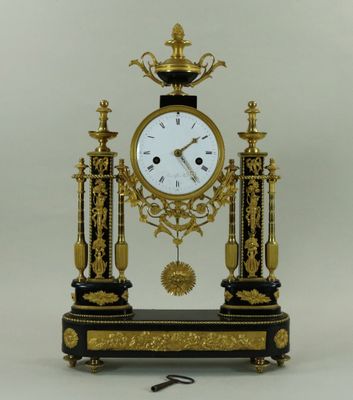 une horloge noire et or posée sur une table