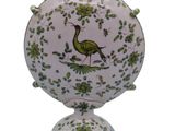 a vase with a bird on it sitting on a stand