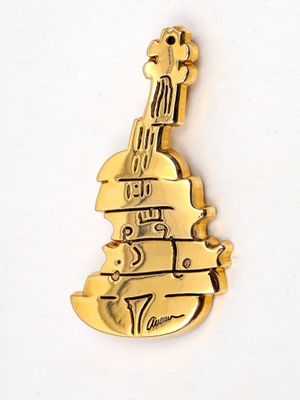 a gold plated violin brooch on a white surface
