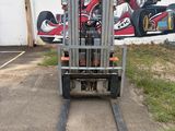 a forklift parked in front of a wall with a painting on it