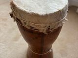 a small wooden drum sitting on the floor in front of a window