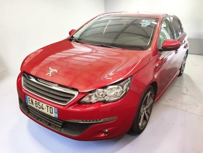 La voiture rouge est garée dans une pièce blanche au sol blanc.