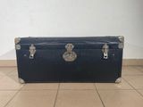 a black trunk sitting on the floor in a room