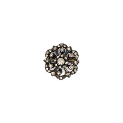 un gros plan d'une broche en forme de fleur sur fond blanc