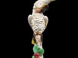 a figurine of a yellow and white cockatoo on a branch