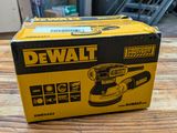 the box is open on a wooden table with a corded sander in it