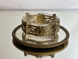 a glass plate with a gold bracelet on it