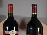 two bottles of wine sitting next to each other on a table