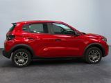 a red car is parked in a room with a white wall