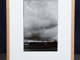 a black and white photo of an empty picture frame on a wooden stand