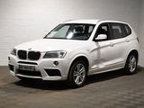 Le SUV BMW blanc est garé dans une pièce blanche.